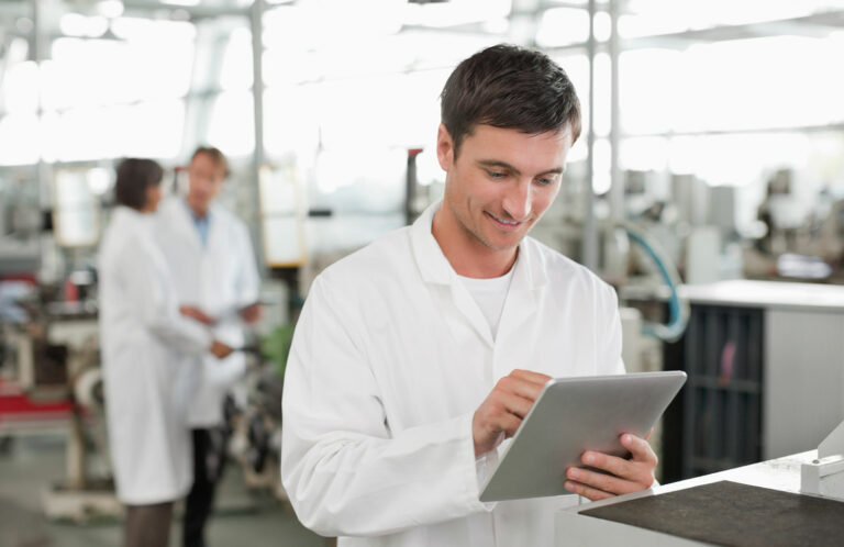 Operator in white coat reading a tablet